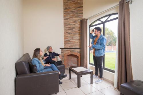 a group of people sitting in a room with a fireplace at Hotel & Glamping Huasca Sierra Verde in Huasca de Ocampo