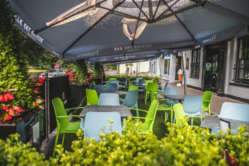 
a patio area with tables, chairs, and umbrellas at Muskerry Arms Bar and B&B in Blarney
