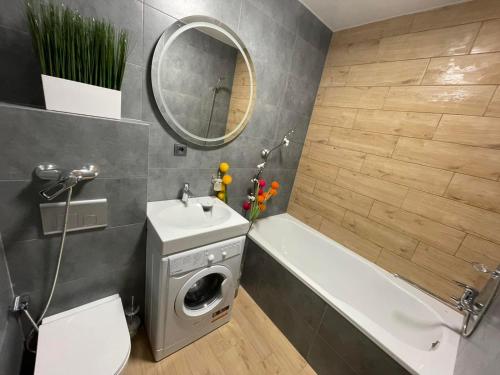 ein Badezimmer mit einem Waschbecken, einem WC und einer Badewanne in der Unterkunft Resident Hall in Lwiw