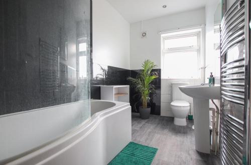 a bathroom with a tub and a sink and a toilet at Contemporary Home in Friendly Easton, Free Parking in Bristol