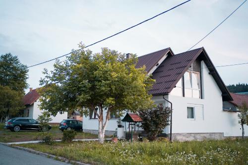 Biały dom z brązowym dachem w obiekcie Rooms & Apartment Milan Saborsko w mieście Saborsko
