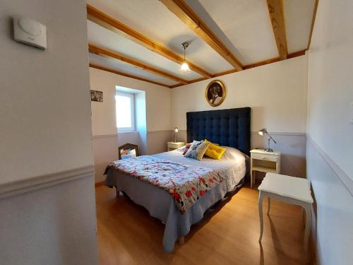 een slaapkamer met een bed met een blauw hoofdeinde bij Chambre d'hôtes LES LOUVES in Saint-Paul-des-Fonts