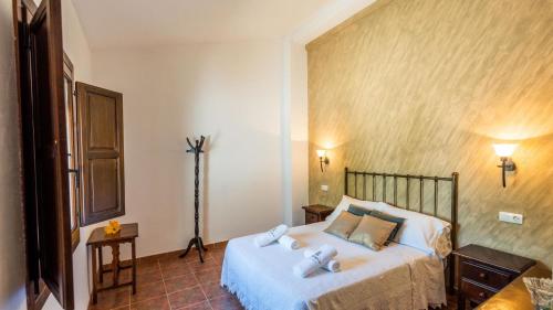 Un dormitorio con una cama y una lámpara. en Cortijo Rica Santa Cruz del Comercio by Ruralidays, en Granada