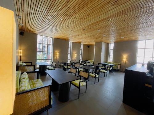 a dining room with tables and chairs and windows at Chospa Hotel, Leh in Leh