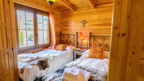 a bedroom with two beds in a log cabin at Casa La Cabana Priego de Cordoba by Ruralidays in Priego de Córdoba