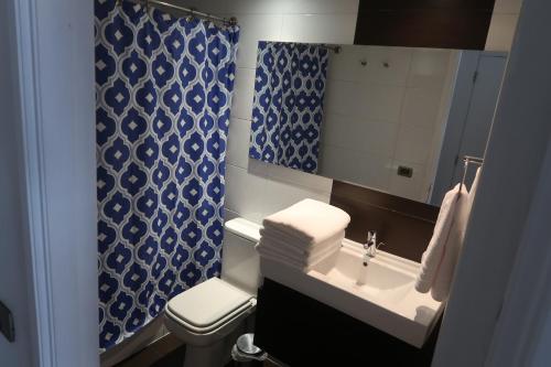 a bathroom with a sink and a toilet and a mirror at Hermoso departamento, excelente ubicación in Santiago