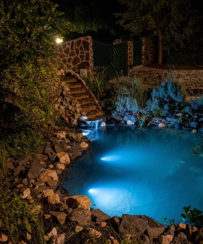 a small pool of blue water at night with a staircase at Bed & Badacsony in Badacsonytördemic