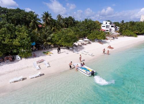 a boat in the water on a beach at Palm Gate Maldives in Thulusdhoo