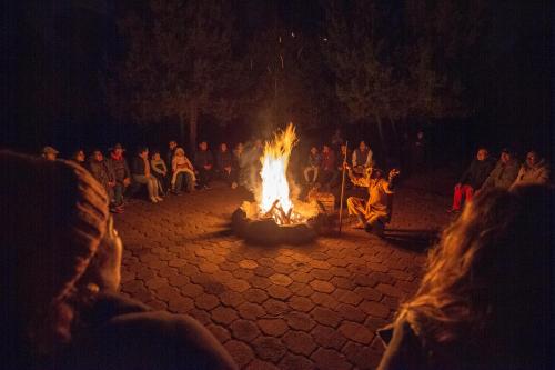 a group of people sitting around a large fire at Hotel & Glamping Huasca Sierra Verde in Huasca de Ocampo