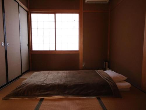 - une chambre avec un grand lit et une fenêtre dans l'établissement Makotoya - Vacation STAY 69812v, à Takayama