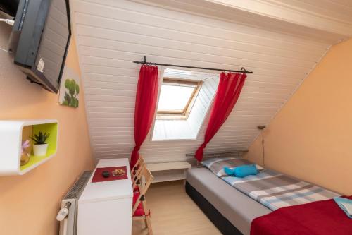 ÜbelbachにあるGasthof Altes Hammerherrenhausのベッドと窓が備わる小さな客室です。