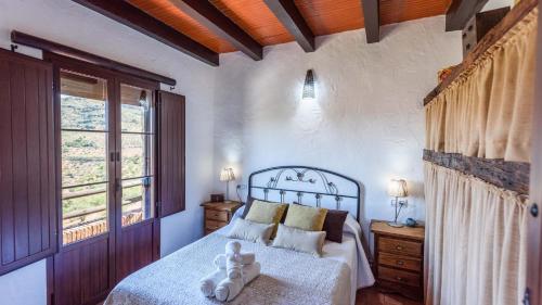 a bedroom with a bed with a teddy bear on it at Casa Jara de El Gastor by Ruralidays in El Gastor