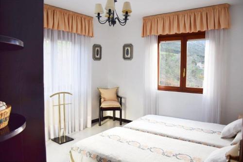 een slaapkamer met 2 bedden en een raam bij Vivienda vacacional El Bosque in Llovio