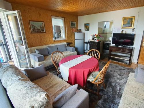ein Wohnzimmer mit einem Sofa und einem roten Tisch in der Unterkunft Apartments Panda in Vlasic