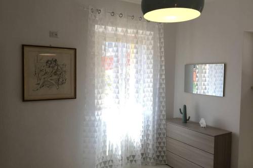 ventana con cortinas blancas en una habitación con vestidor en Casa Belvedere, en Colonnella
