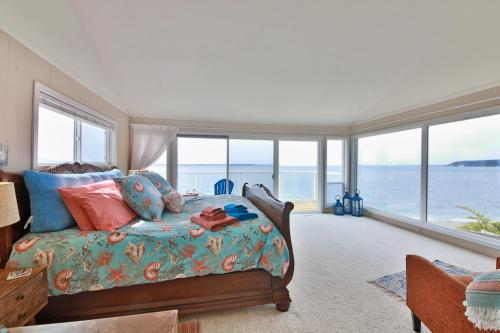 a bedroom with a bed with a view of the ocean at Spyglass Beach House in Freeland