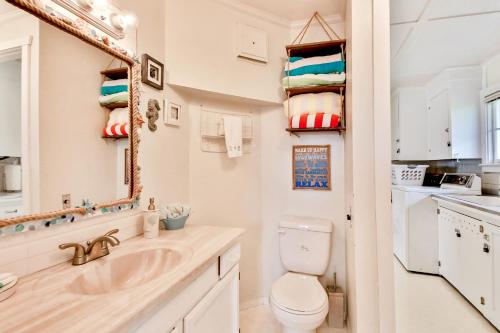 a bathroom with a sink and a toilet and a mirror at Spyglass Beach House in Freeland