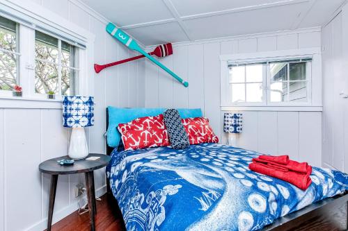 a bedroom with a bed with blue and red pillows at Spyglass Beach House in Freeland