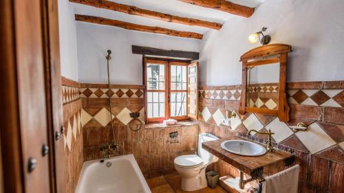 uma casa de banho com um lavatório, um WC e um espelho. em Villa Montilla Frigiliana by Ruralidays em Frigiliana
