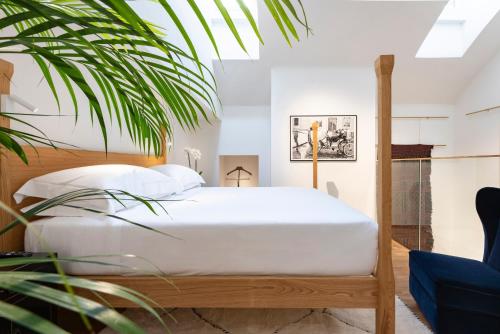 um quarto com uma cama com lençóis brancos e uma planta em Vico Milano em Milão