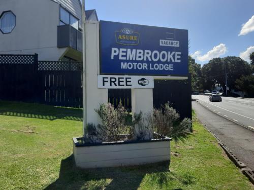 a sign for a motor lodge in front of a building at Pembrooke Motor Lodge in Whangarei