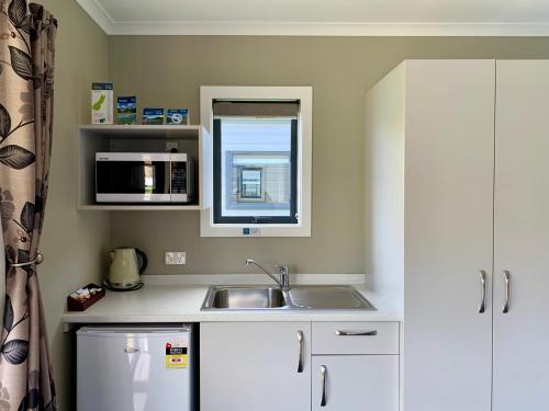 a small kitchen with a sink and a microwave at Omarama TOP10 Holiday Park in Omarama