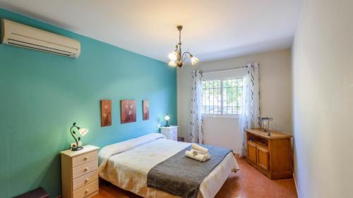 Schlafzimmer mit blauen Wänden, einem Bett und einem Fenster in der Unterkunft Casa Rio Grande Tolox by Ruralidays in Tolox