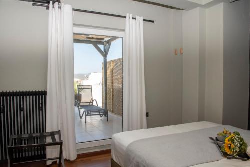 a bedroom with a bed and a view of a balcony at Luxury Premium Suite in Chalkida in Chalkida