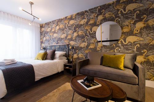 a bedroom with a bed and a couch and a mirror at Fun & Funky Little Italy Studio with Full Kitchen by Den Stays in Montréal