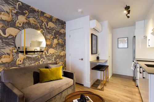 a living room with a couch and a mirror at Fun & Funky Little Italy Studio with Full Kitchen by Den Stays in Montréal