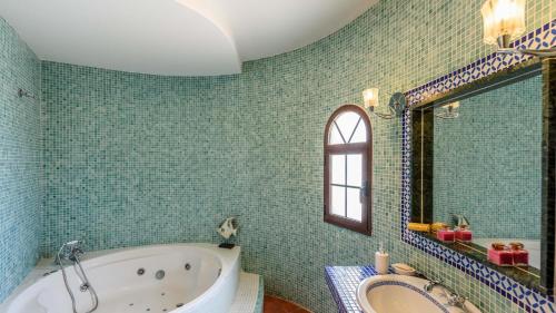 uma casa de banho com uma banheira e um espelho. em Villa Asuncion Arenas by Ruralidays em Arenas