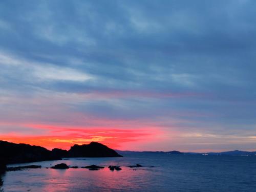 a sunset over the ocean with a mountain in the background at Le studio de giens in Hyères