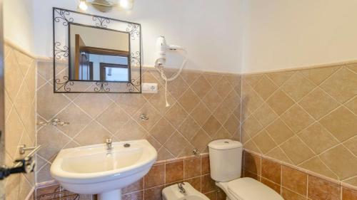 a bathroom with a sink and a toilet and a mirror at Casa Los Bancales Cortes de la Frontera by Ruralidays in Cortes de la Frontera