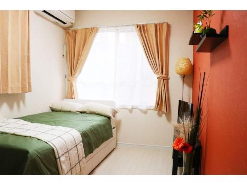 a bedroom with a bed and a window at OHANA TOKYO HOUSE - Vacation STAY 73215v in Tokyo