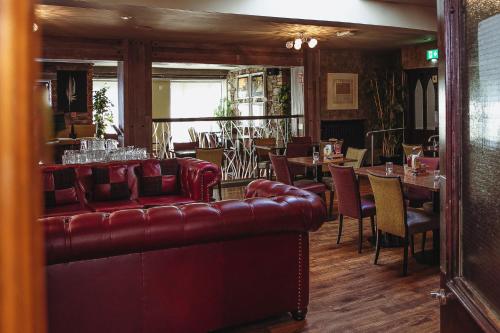 a restaurant with a couch and tables and chairs at Muskerry Arms Bar and B&B in Blarney