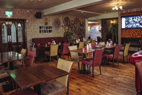 a restaurant with tables and chairs and a tv at Muskerry Arms Bar and B&B in Blarney