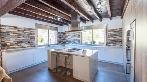 a kitchen with white counters and blue cabinets and windows at Casa El Hoyillo El Gastor by Ruralidays in El Gastor