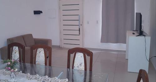 a dining room with a table and chairs and a television at Sobrado 2 amplo e confortável em condomínio in Corumbá