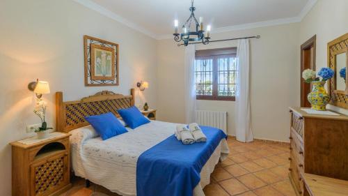 Villa Antisa Villanueva de la Concepcion by Ruralidays في فيلانويفا دي لا كونسيبسيون: غرفة نوم مع سرير مع لحاف أزرق