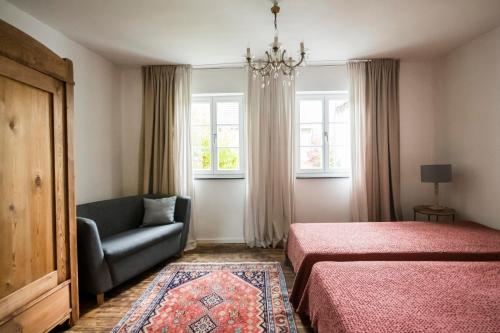 een slaapkamer met een bed, een stoel en een raam bij Landleben auf Zeit in Utzerath