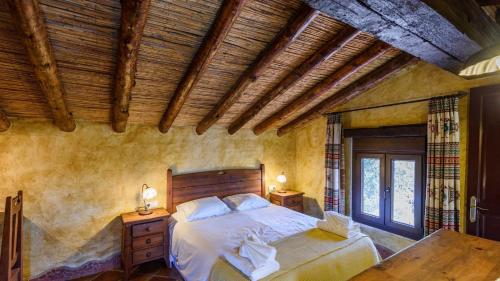 ein Schlafzimmer mit einem Bett und einer Holzdecke in der Unterkunft Finca Algarabia Competa by Ruralidays in Cómpeta