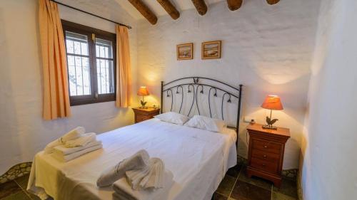 a bedroom with a large white bed with two night stands at Finca Almencino Competa by Ruralidays in Cómpeta