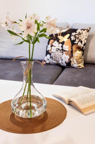 a vase with flowers on a table next to a book at Smart Executive in Kraków