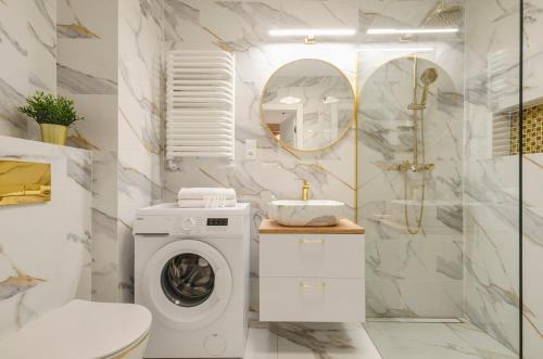een badkamer met een wasmachine en een toilet bij Manufaktura Centrum in Łódź