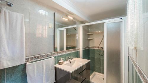 een badkamer met een wastafel, een douche en een spiegel bij Casa Gonzalez Almunecar by Ruralidays in Almuñécar