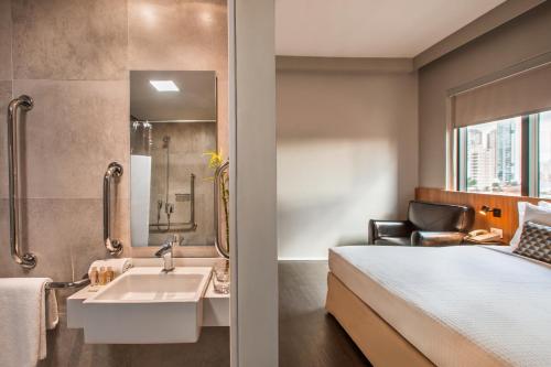 a bathroom with a bed and a sink in a room at São Paulo Tatuape, Affiliated by Meliá in São Paulo
