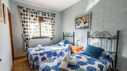 - une chambre avec 2 lits avec des draps bleus et blancs dans l'établissement Villa Las Dehesas Casabermeja by Ruralidays, à Casabermeja