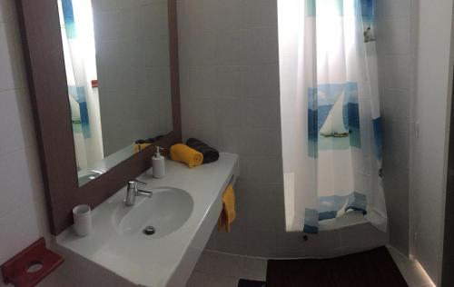a bathroom with a sink and a mirror at Studio COEUR PASSION VUE MER charme et standing in Saint-François