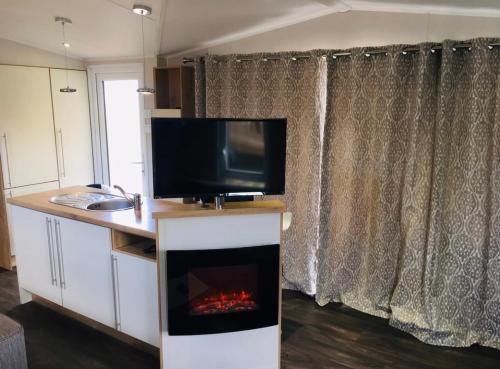 sala de estar con TV y chimenea en Camping -Domaine de Dugny en Onzain