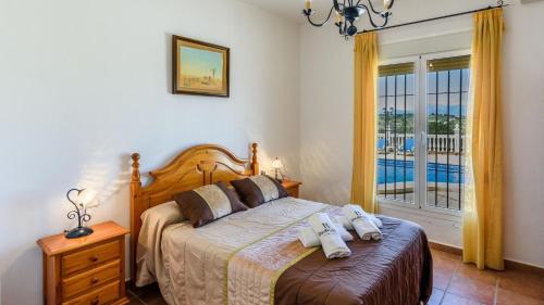 アラウリン・デ・ラ・トレにあるVilla Galiano Alhaurin de la Torre by Ruralidaysのベッドルーム1室(ベッド1台、タオル2枚付)